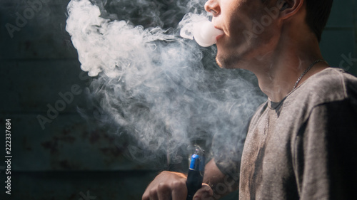 vape man. the modern young person produces clouds of vapor photo