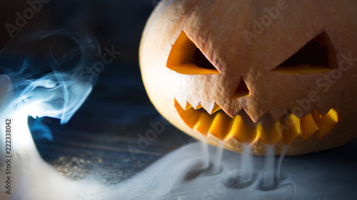 Fotografie Scary and evil pumpkin on Halloween with smoke from the mouth and creep facial e