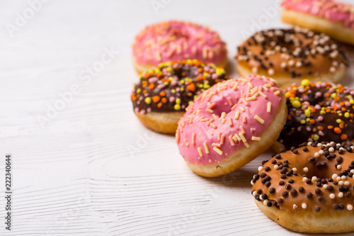 assorted donuts with chocolate frosted, pink glazed and sprinkles donuts.