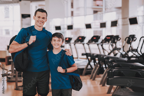 Young Father and Son near Treadmills in Modern Gym