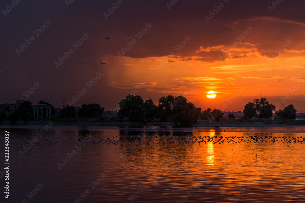 A Dark Orange Lake Sunset and a Lot of Silhouettes