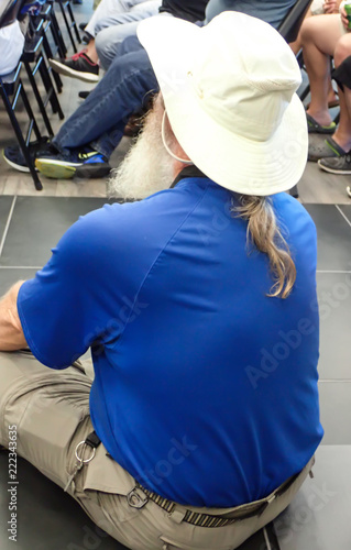 Man with Hat and Beard Sitting Listening to Seminar