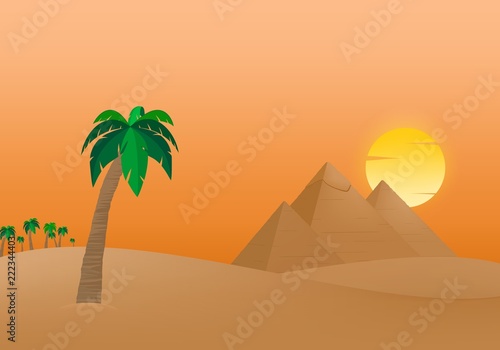 The Egyptian Pyramids of Giza at sunrise in the dune sand with orange sun in the background of palm trees with brown trunk with green leaves