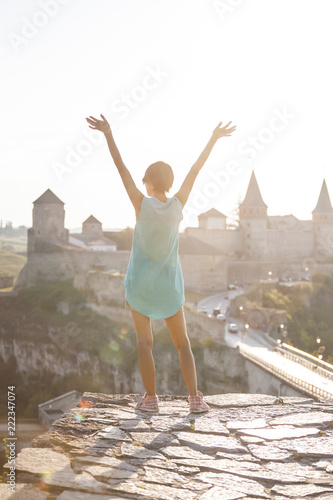 Girl on the background of a medieval fortress.