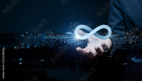 Obraz na płótnie Businesswoman shows sign of infinity on the background of the city