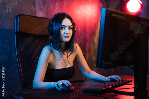 Fotografie, Obraz Beautiful Professional Gamer Girl Playing in First-Person Shooter Online Video Game on Her Personal Computer