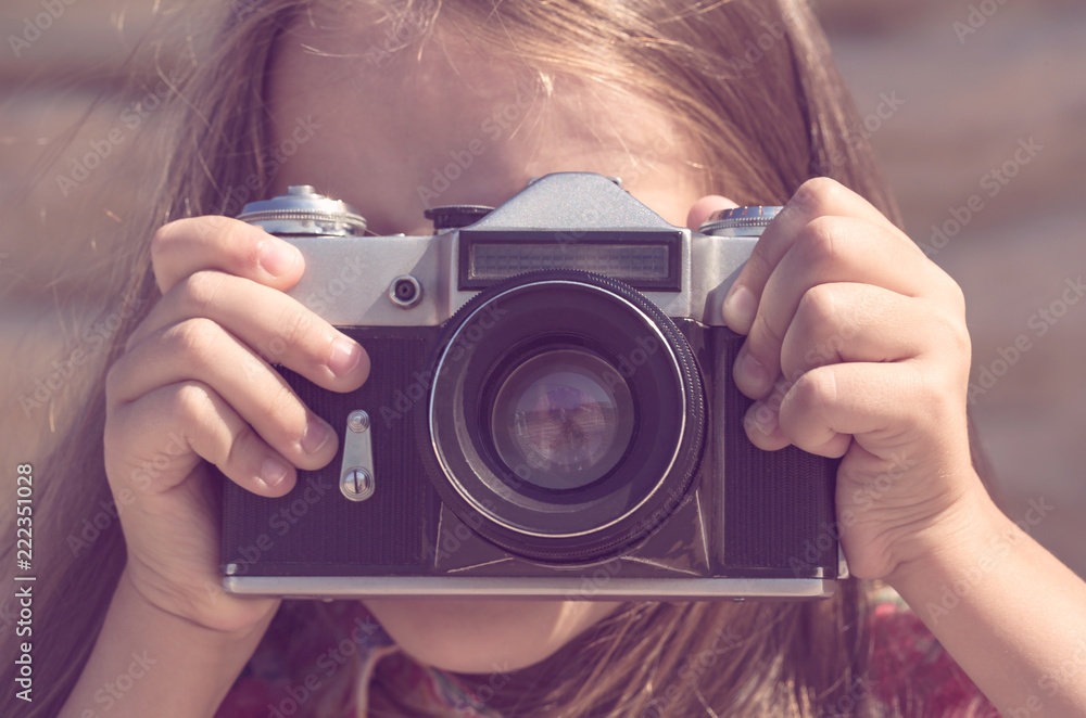 The girl photographs an old Soviet camera in brown tonting. The girl photographs an old Soviet camera in brown tonting.
