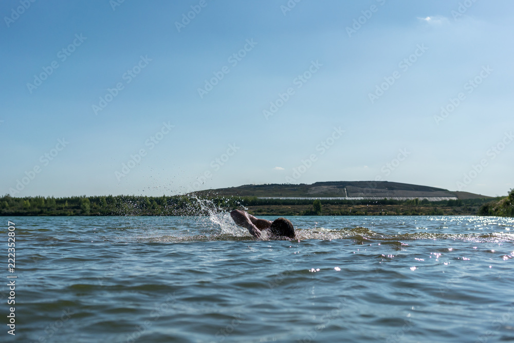 Fototapeta premium Man swimming in a lake