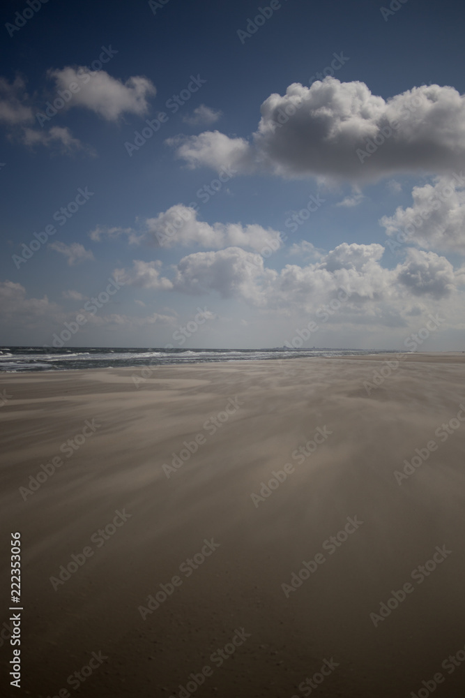 Wolken, Himmel und Sonne über dem Strand und Wattenmeer von Juist