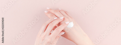 Woman moisturizing her hand with cosmetic cream