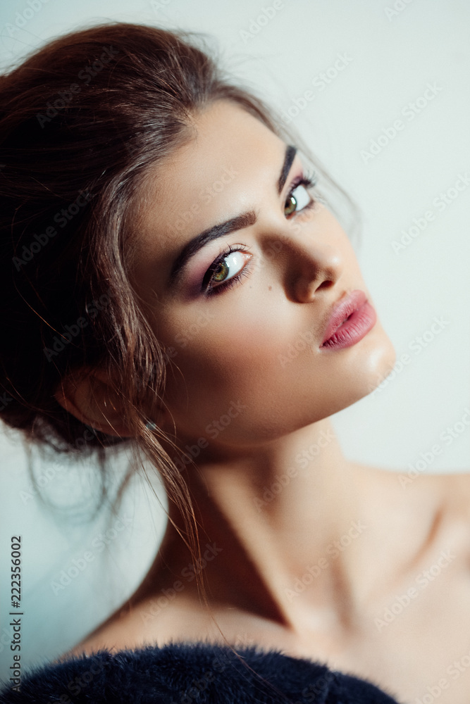 Fototapeta premium Portrait of beautiful young brunette woman with makeup