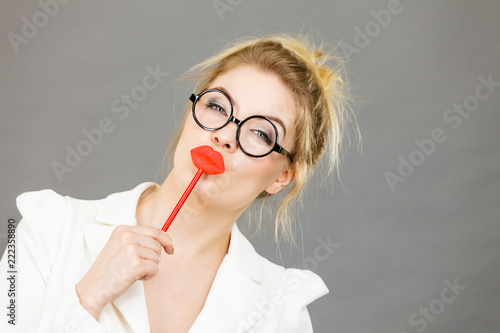 Happy elegant woman holding carnival accessoies on stick