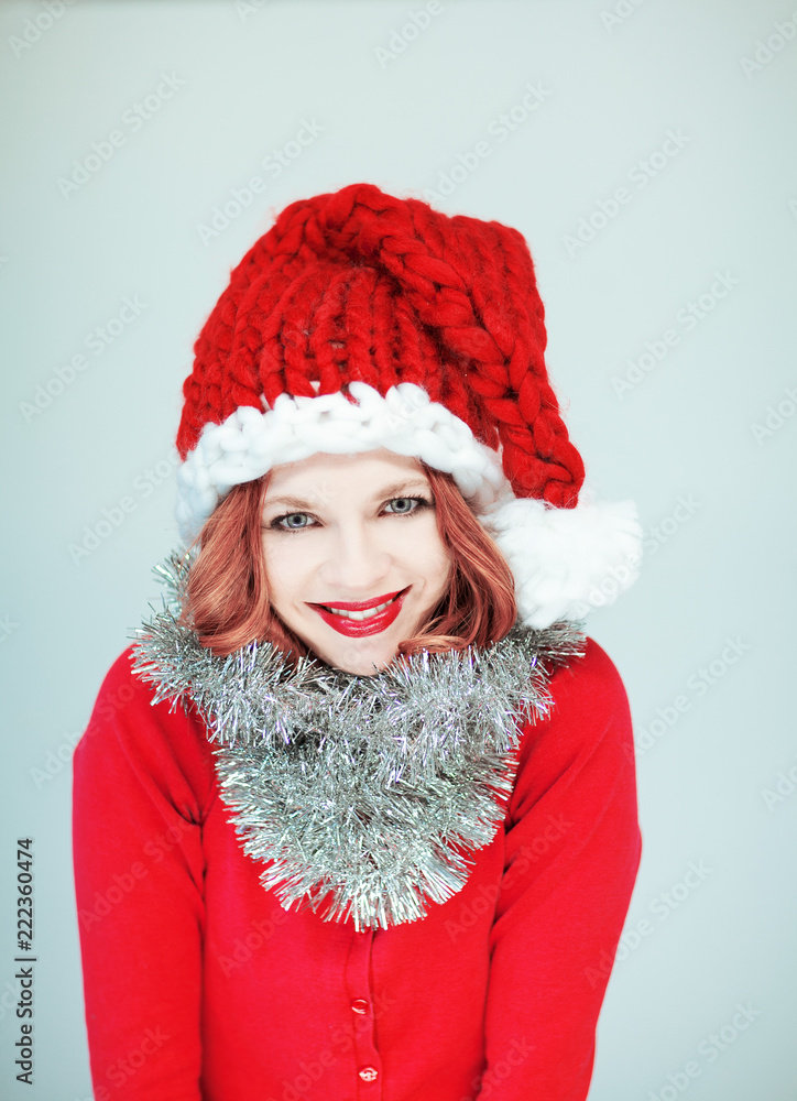 Beautiful happy young woman in a santa claus costume with perfect make up and red lipstick Beautiful happy young woman in a santa claus costume with perfect make up and red lipstick