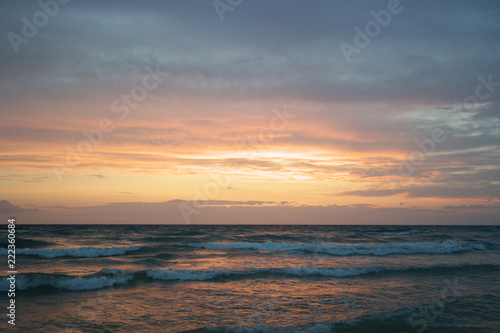 Beach at sunset with big clouds and colors in Salento - Italy