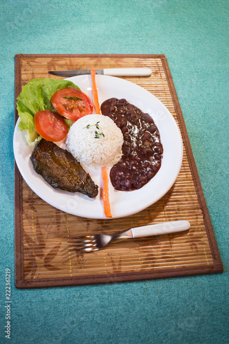 Brasileirinho - Brazilian made typical dish of beans with rice with salad of lettuce, tomato and carrot and steak. photo