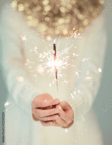 Canvastavla Beautiful woman hands holding sparkler lights, cozy, bright winter sweater with