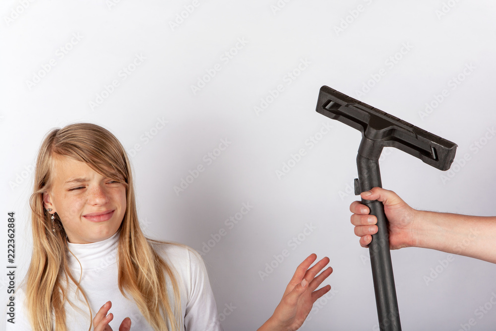 Girl refusing a hand holding a vacuum cleaner floor tool. Childre hate housework concept. Girl refusing a hand holding a vacuum cleaner floor tool. Childre hate housework concept.