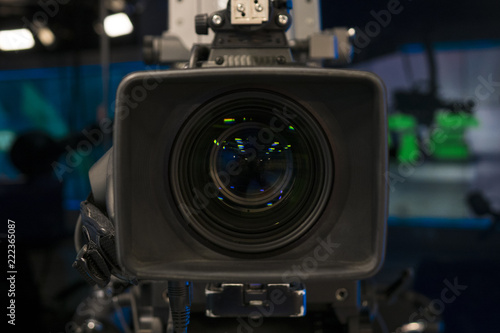 Television Film Camera with focus on the rim of the lens. On Air Broadcast sign in the background.