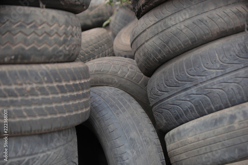 close up of a pile of used black dusty tires, outdoors, on street in the Gambia, with natural light