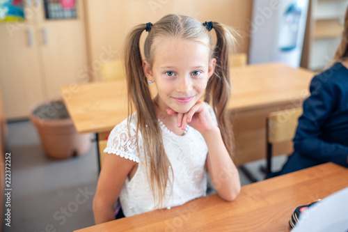 Adorable little school girl with notes and pencils outdoor. photo