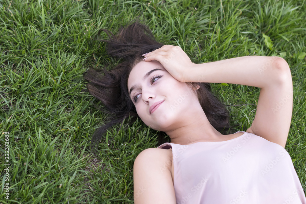 Brunette woman resting outside on grass Brunette woman resting outside on grass
