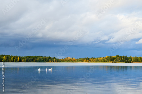 Sunset on the lake in autumn with cloudy sky and reflection in water. Natural background.