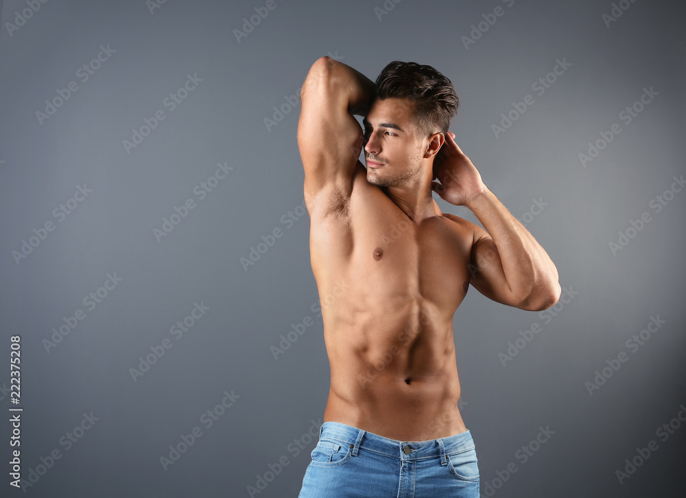 Fototapeta premium Shirtless young man in stylish jeans on grey background