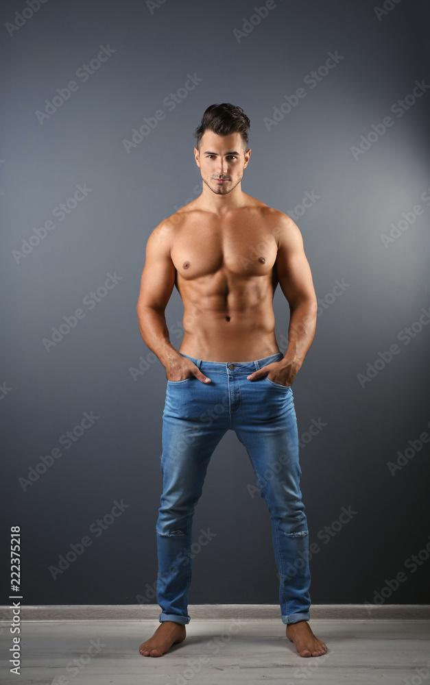 Shirtless young man in stylish jeans near grey wall Shirtless young man in stylish jeans near grey wall