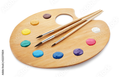 Palette with paints and brushes on white background photo