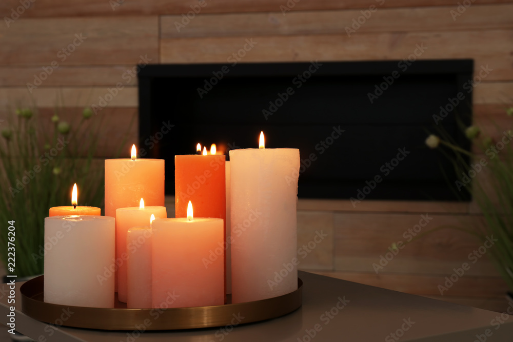 Tray with burning candles on table in living room Tray with burning candles on table in living room