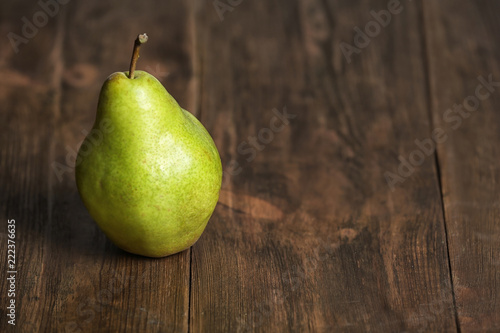Ripe pear on wooden background. Space for text