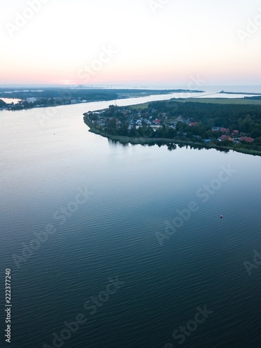 Beautiful sunset over estuary of Vistula river in Gdansk. Summer sunset over sea and river and small village.