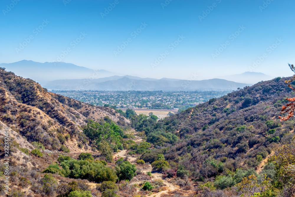 Hiking and biking dirt trails in Southern California mountains with city in distance and blue sky for copy text