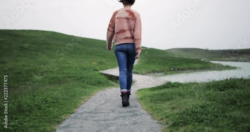 Millennial walking on a path into countryside photo