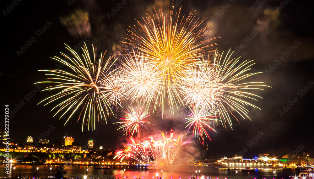 White, green, and yellow fireworks in front of Quebec City during a summer festival. White, green, and yellow fireworks in front of Quebec City during a summer festival.