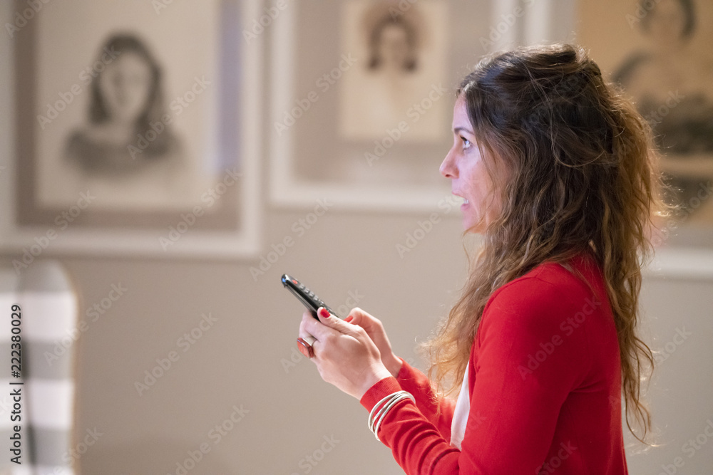Upset cute girl changing channels with the remote control trying to find something on TV expressing her emotions with the TV, a nice relation Upset cute girl changing channels with the remote control trying to find something on TV expressing her emotions with the TV, a nice relation