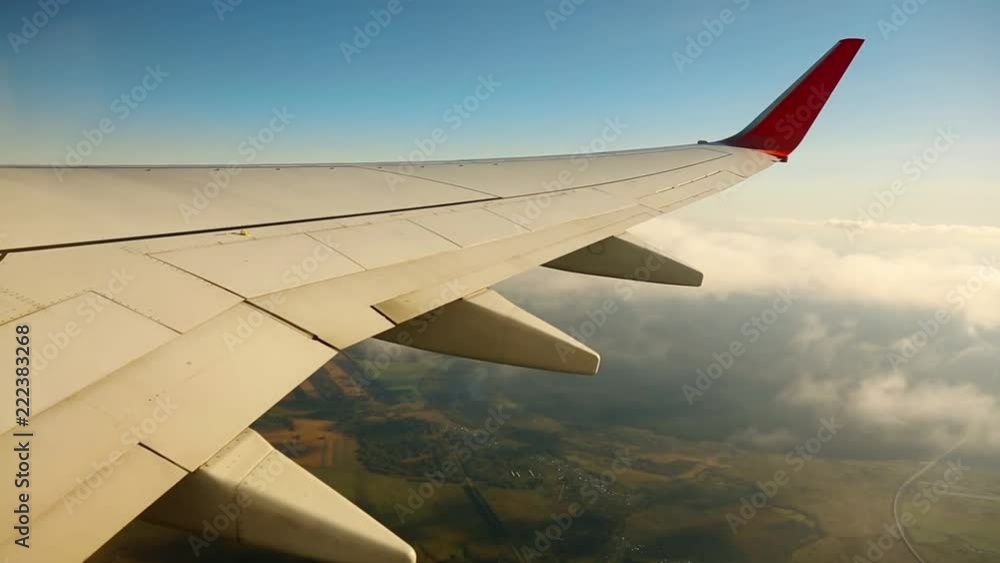 Wing of an airplane in the sky. The plane flies through the clouds Wing of an airplane in the sky. The plane flies through the clouds