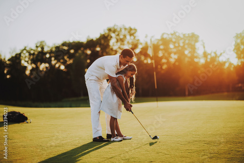 Father Playing Golf with Little Daughter on Field.