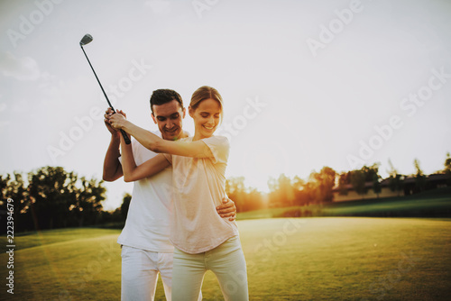 Young Happy Couple Playing Golf on Field in Summer