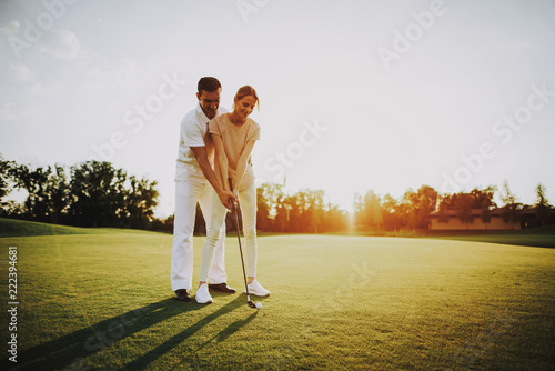 Young Happy Couple Playing Golf on Field in Summer