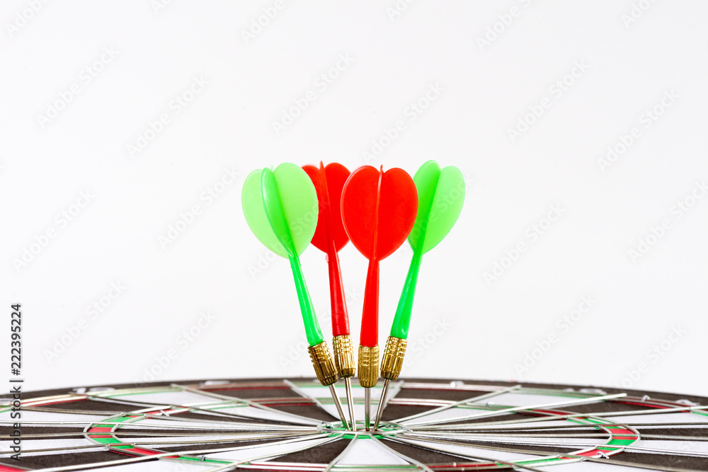 Fototapeta premium Close up shot green and red darts arrows in the target center. Business target or goal success and winner concept.
