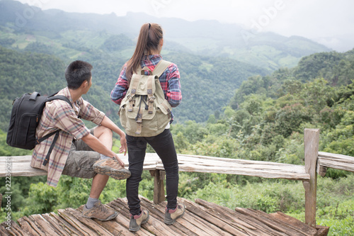 Couple Man and Woman sitting on cliff enjoying mountains and clouds landscape Love and Travel happy emotions Lifestyle concept. © Tinnakorn