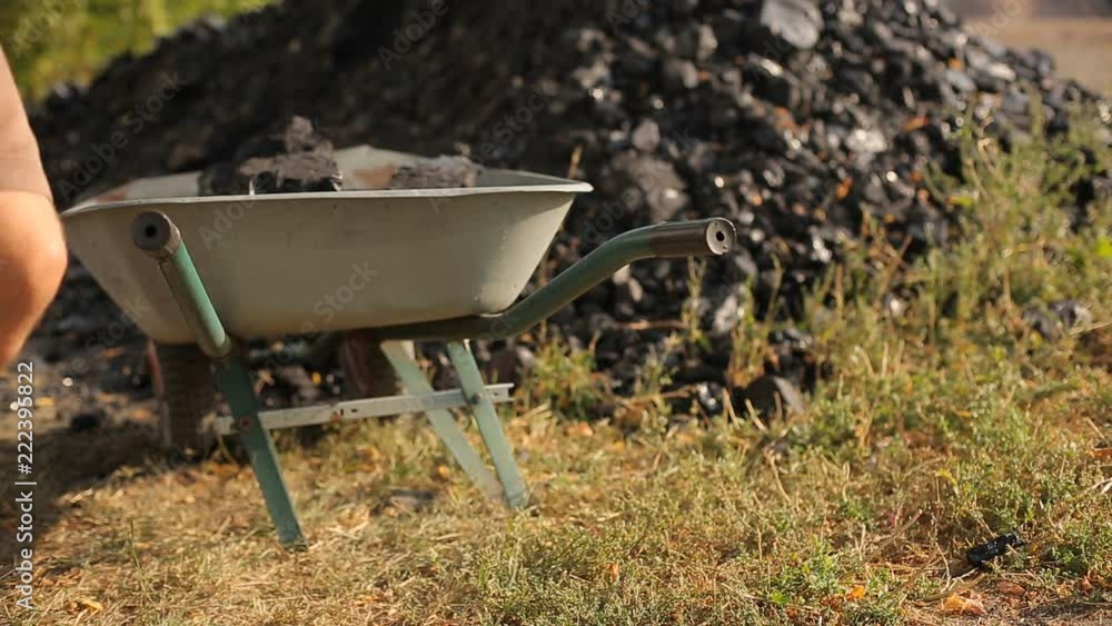 a poor man loads natural coal in a truck with a shovel a poor man loads natural coal in a truck with a shovel
