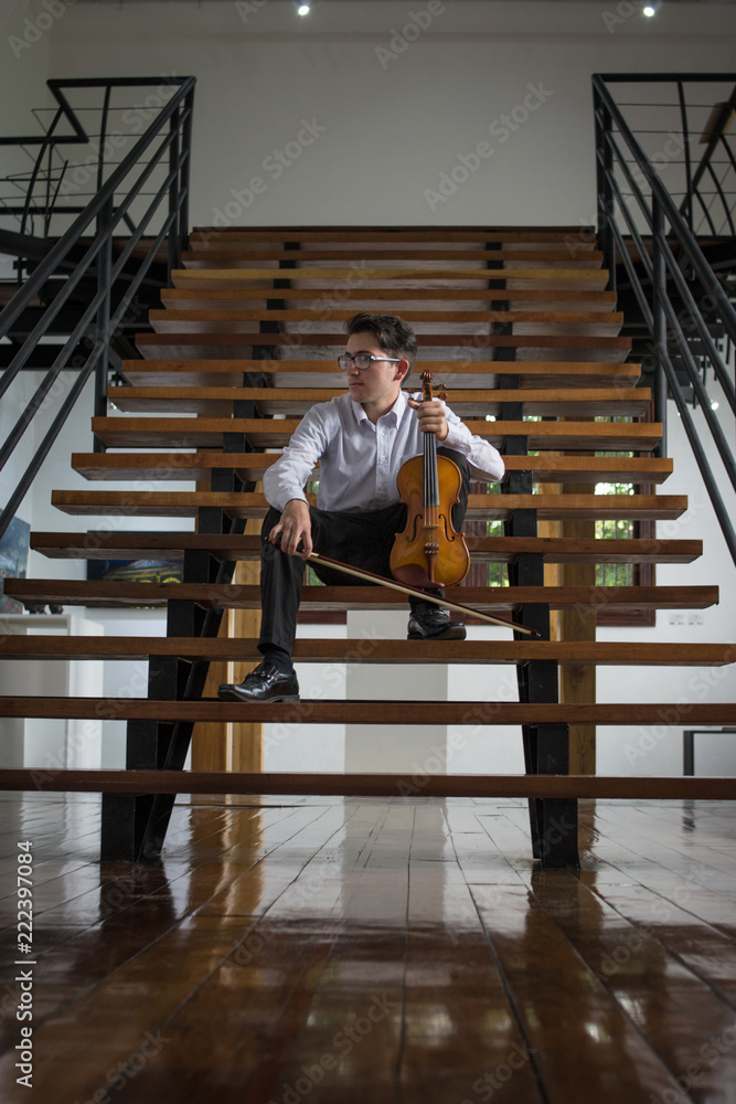 portrait of violinist sitting on the stairs portrait of violinist sitting on the stairs