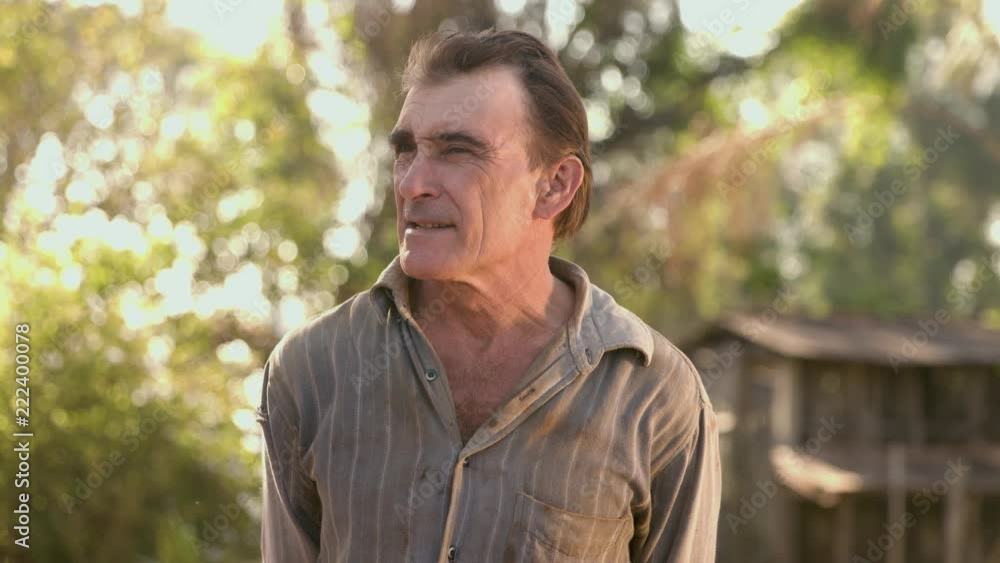 Middle aged farmer on farmland smiling looking at the camera Middle aged farmer on farmland smiling looking at the camera