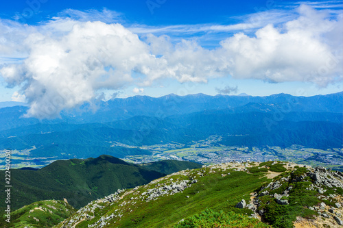 Clouds float above the mountain range. View of the city from top of the mountain in Central Alps, Nagano Prefecture, Japan.