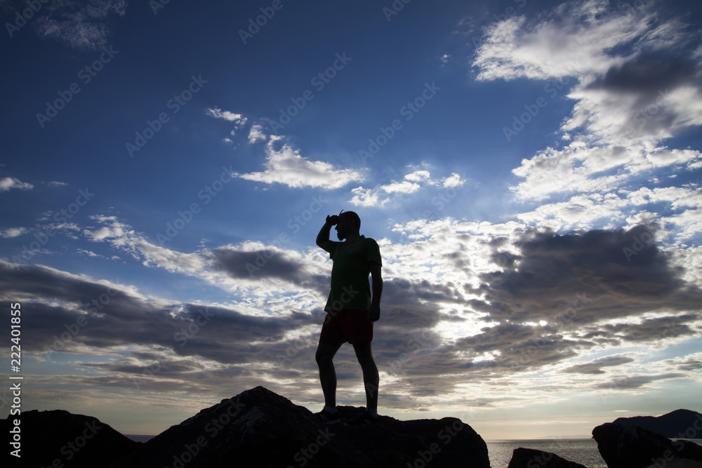 Man standing on the cliffs in sunset