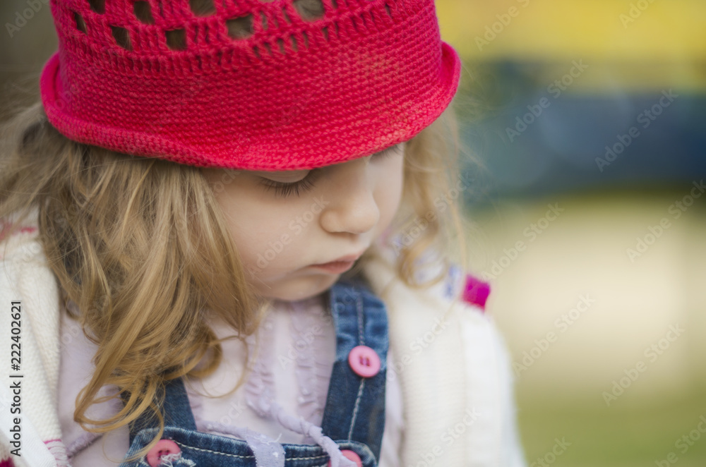 Shallow depth of field close up shot of a cute girl with curly blonde hair. She looks sad and lonely. Looking down. Shallow depth of field close up shot of a cute girl with curly blonde hair. She looks sad and lonely. Looking down.