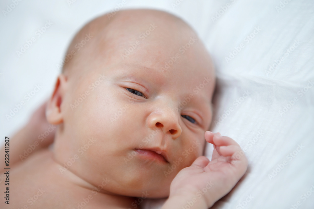 The baby naked lies on her back. The baby naked lies on her back.