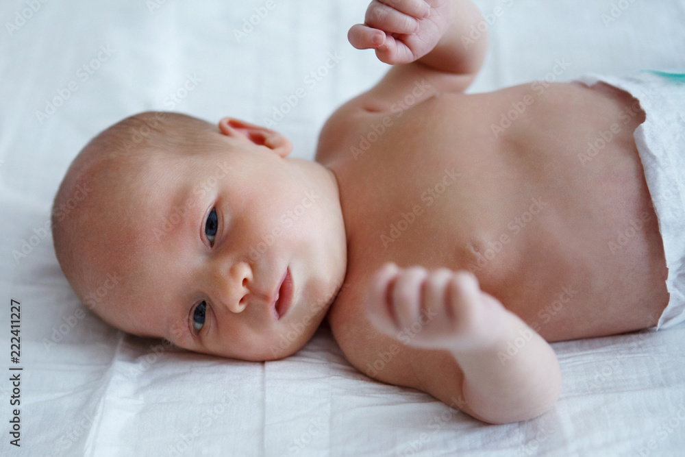 The baby naked lies on her back. The baby naked lies on her back.